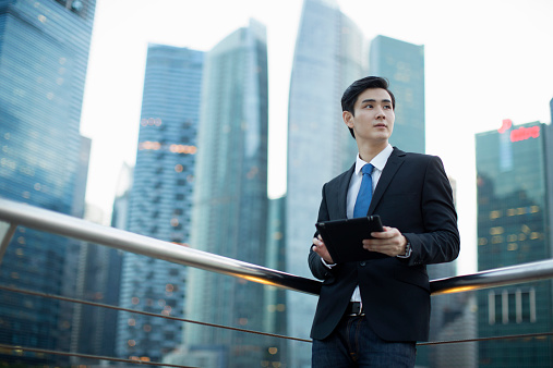 Young man holding a digital tablet in city